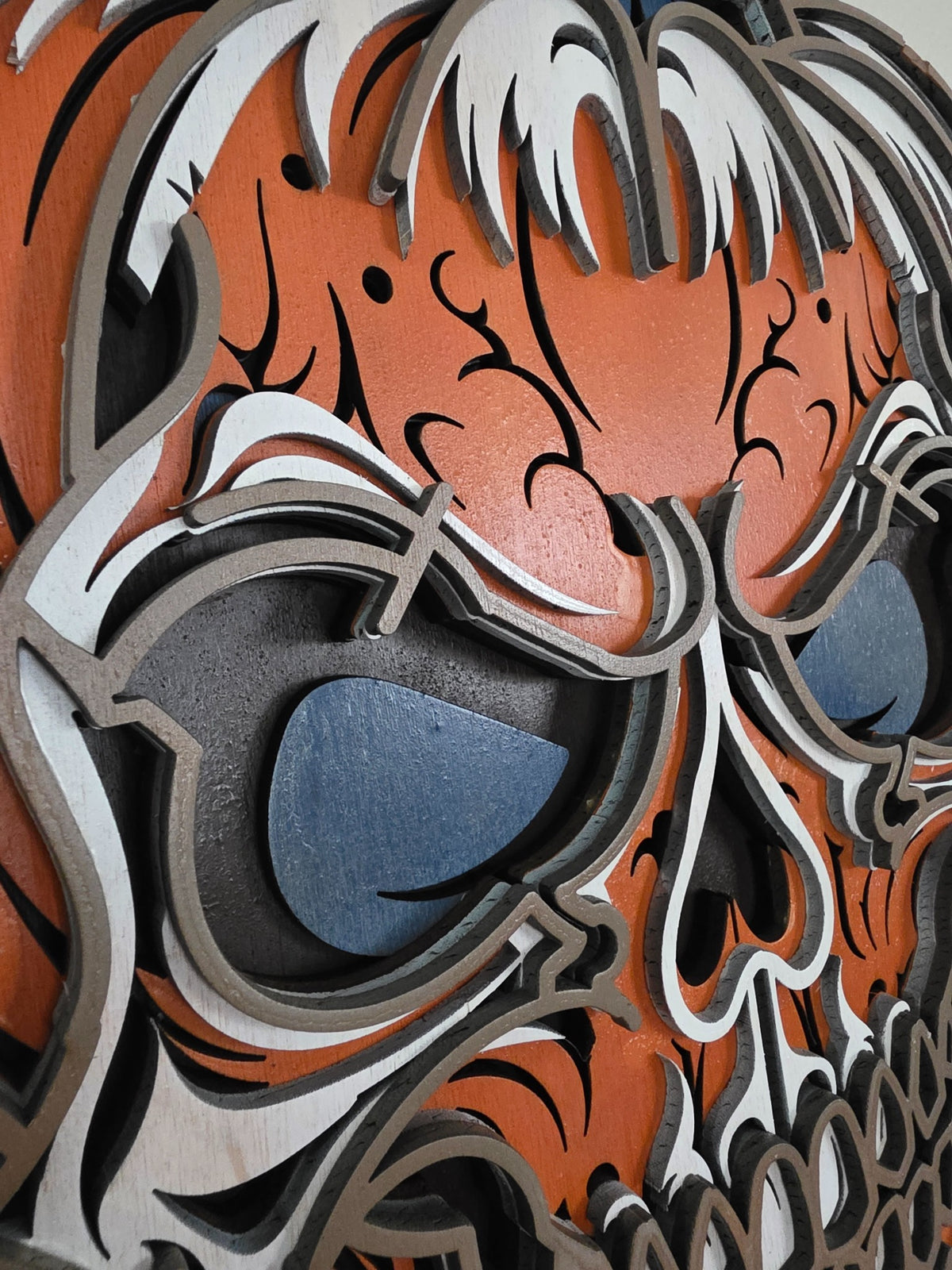 Close-up detail of pumpkin skull eyes and layered wood construction