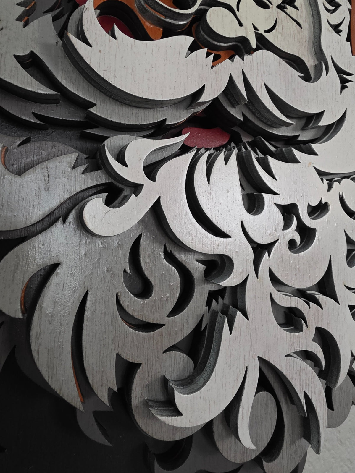 Close-up detail of Santa Claus beard and layered wooden Christmas wall art construction