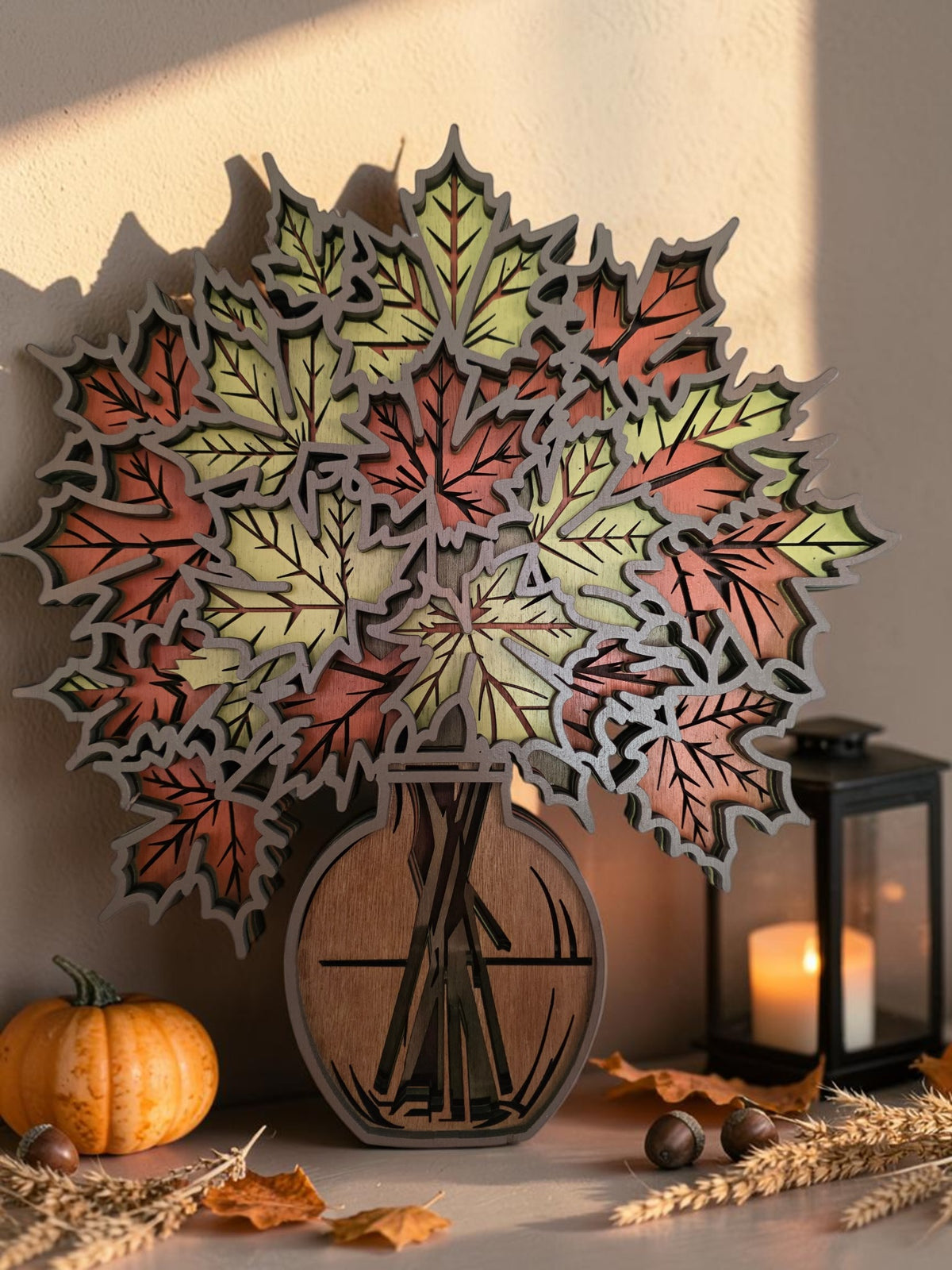 Layered wooden fall maple leaf bouquet in a vase, styled with pumpkin, lantern, wheat, and warm autumn decor