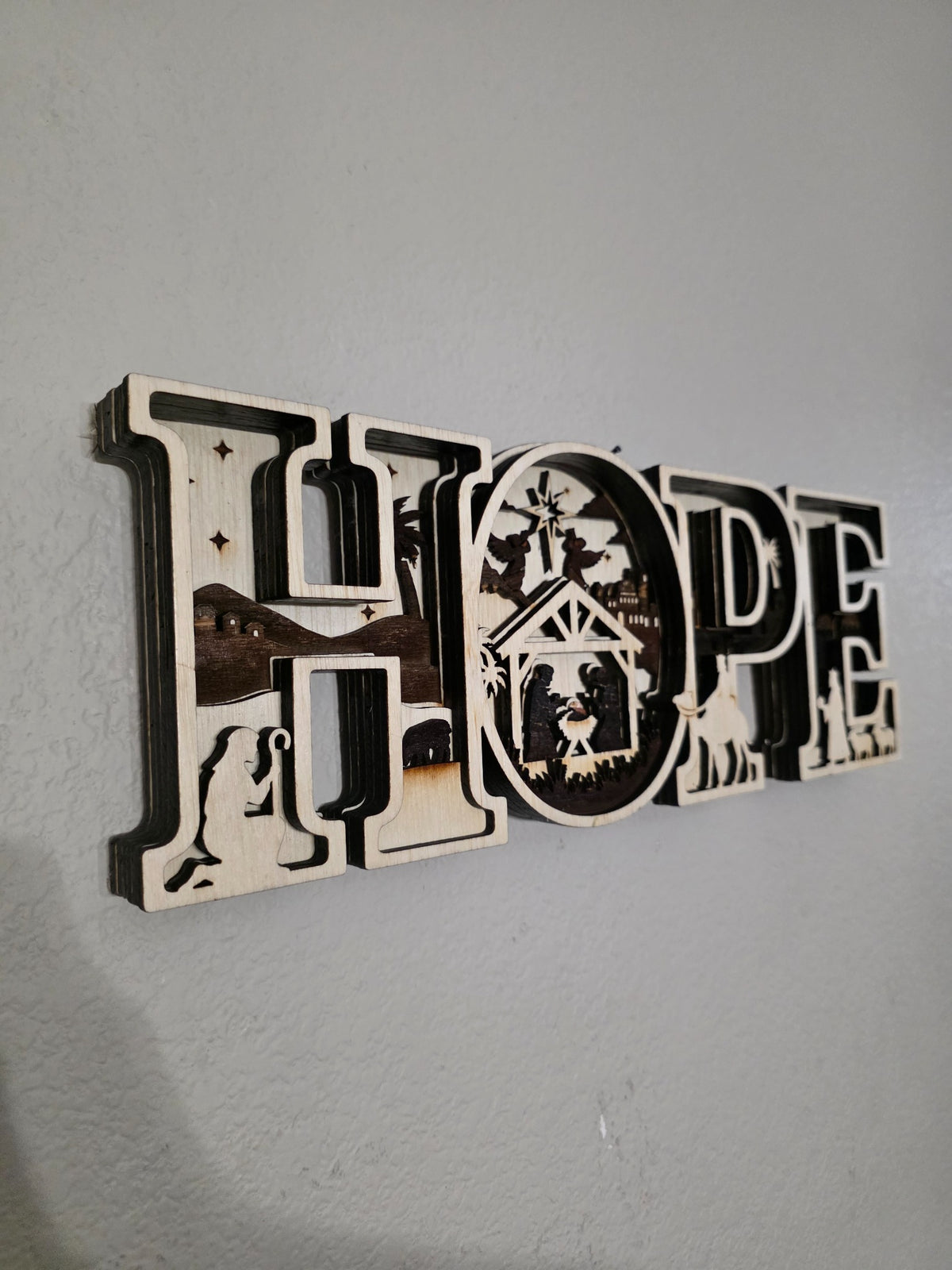 Left angle of HOPE nativity layered wood wall art showing dimensional layers