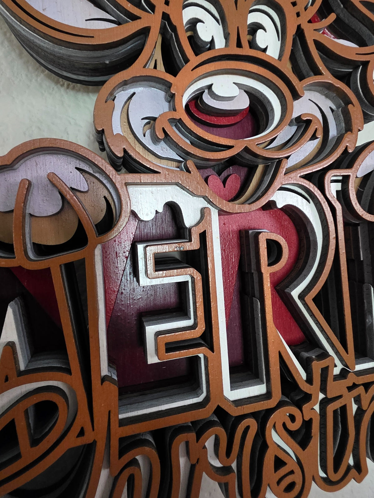 Close-up detail of layered Merry Christmas reindeer wall art center and dimensional lettering