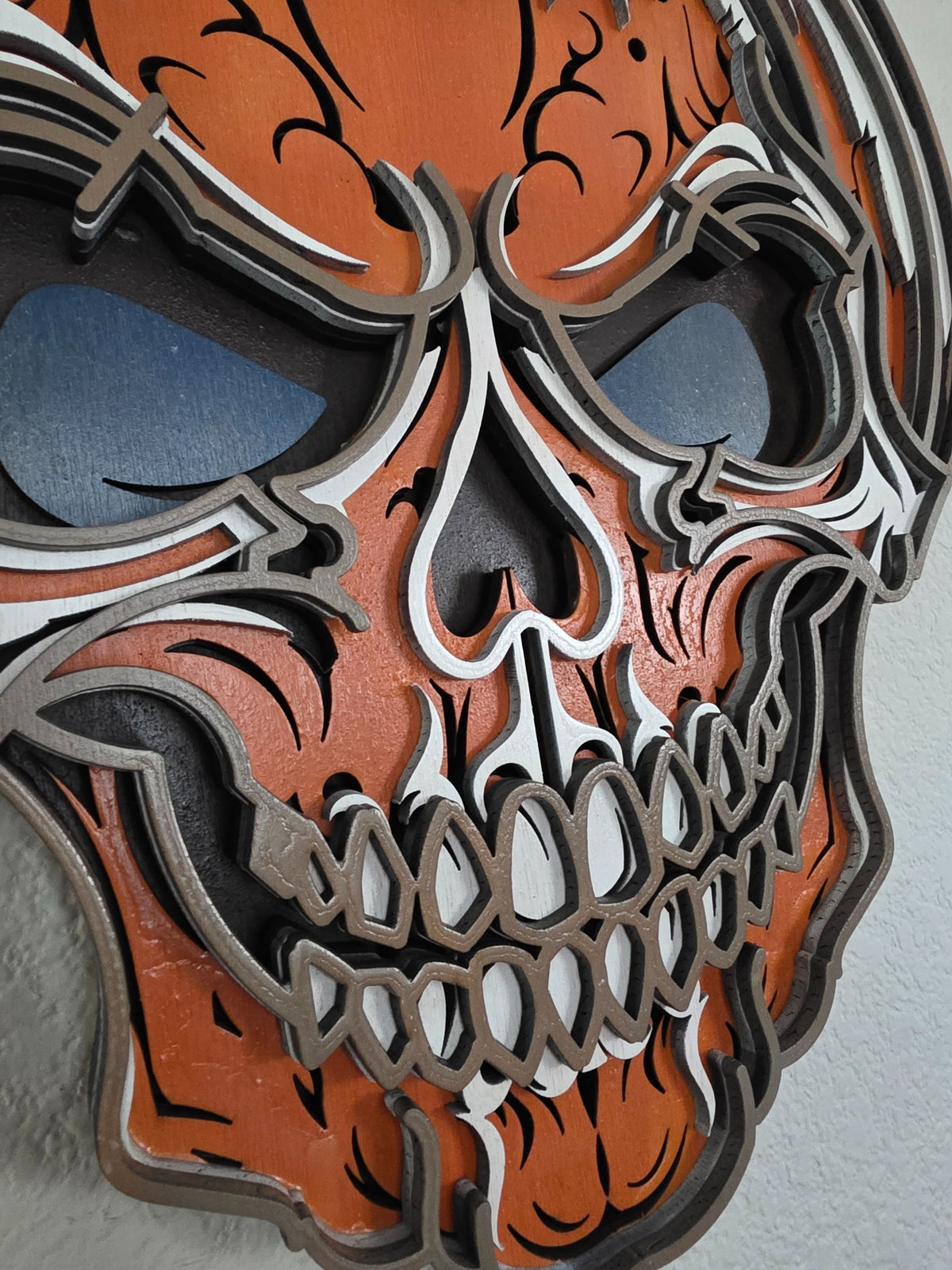Close-up detail of layered pumpkin skull teeth, nose, and dimensional wood craftsmanship