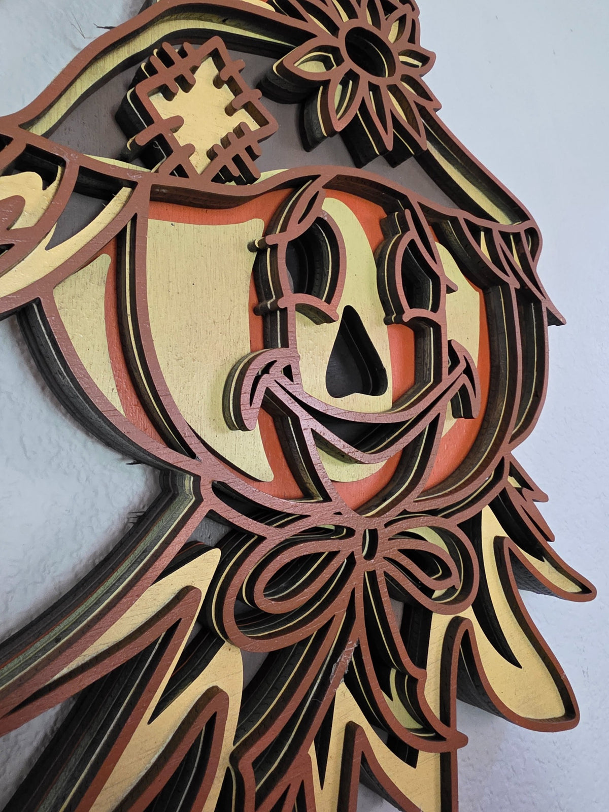 Layered wooden scarecrow pumpkin witch wall art styled with pumpkins, sunflowers, wheat, and warm fall decor