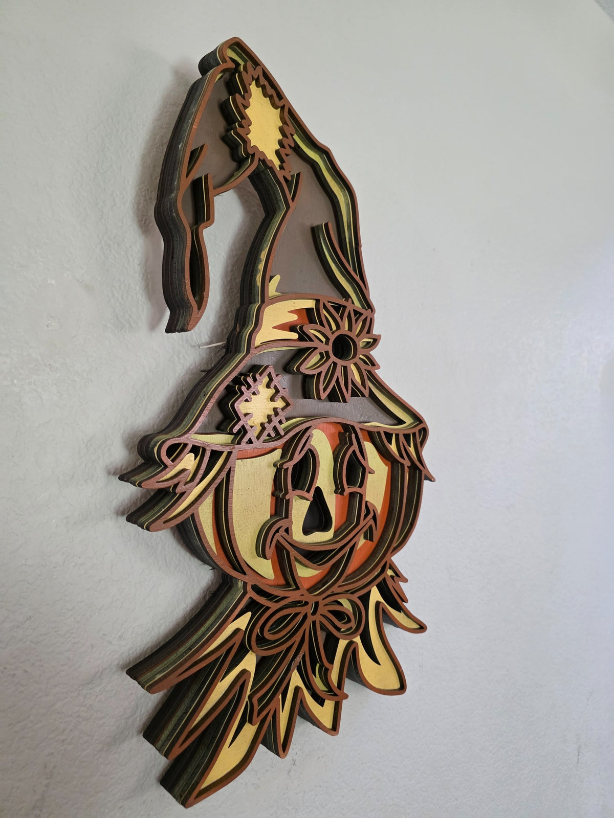 Side view of layered wooden scarecrow pumpkin witch wall art showing dimensional wood layers